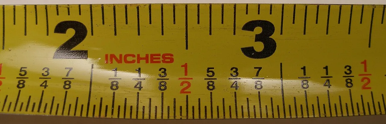 Close-up of an inch tape measure marked with eighths, quarters and halves