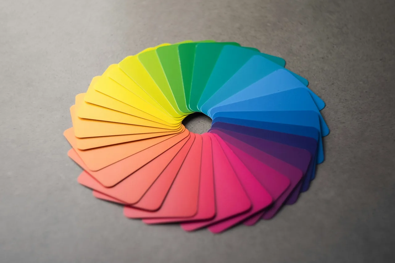 Colour swatch cards laid out in a wheel, from yellow through green and blue to pink