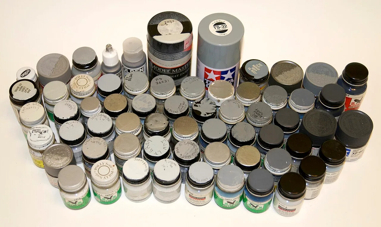 Several dozen pots of paint in shades of gray, each with its own label