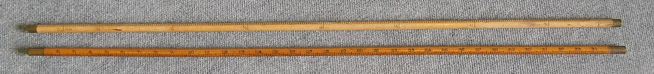 Two wooden yardsticks with an inch scale