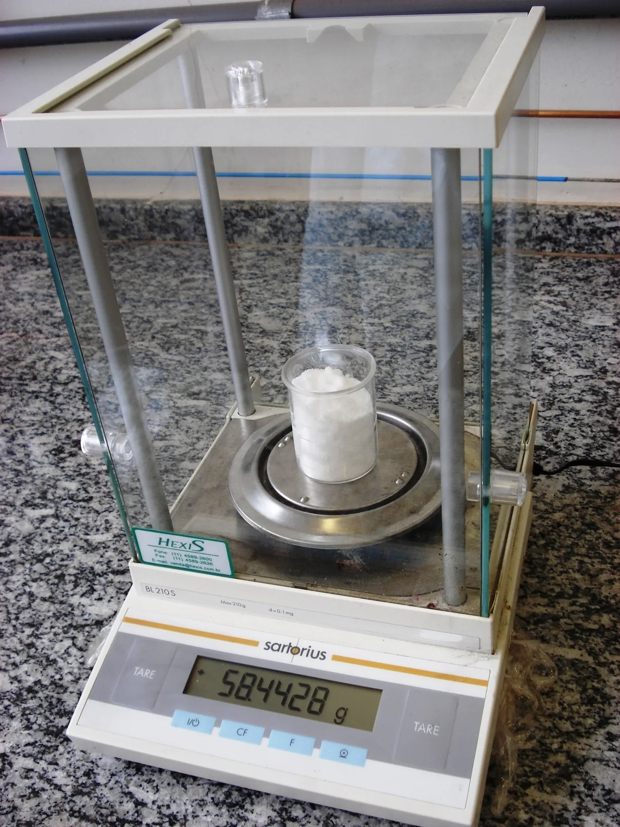 Laboratory balance holding a weighed portion of salt