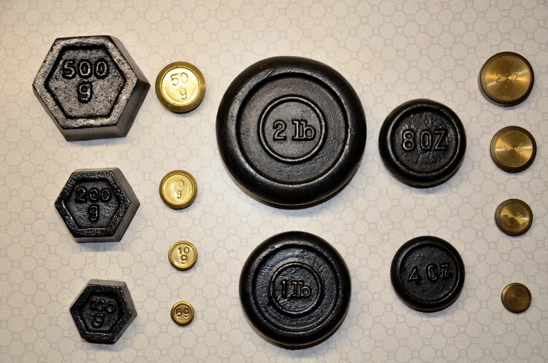 Kitchen scale weights marked 500 g, 200 g, 100 g, 50 g, 20 g, 10 g and 5 g, with pound and ounce weights beside them
