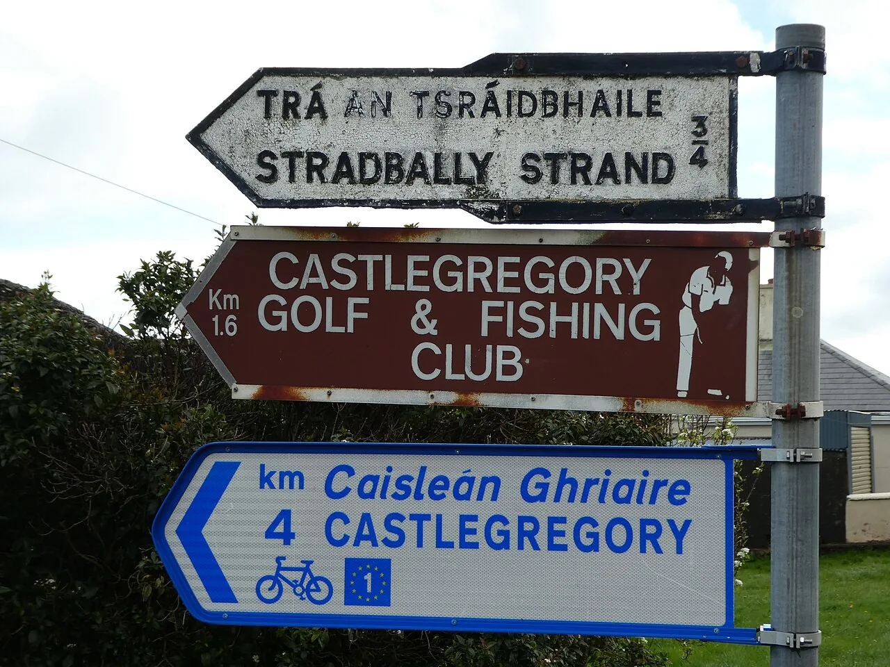 Irish signpost with an old fingerpost in miles and newer plates in kilometres