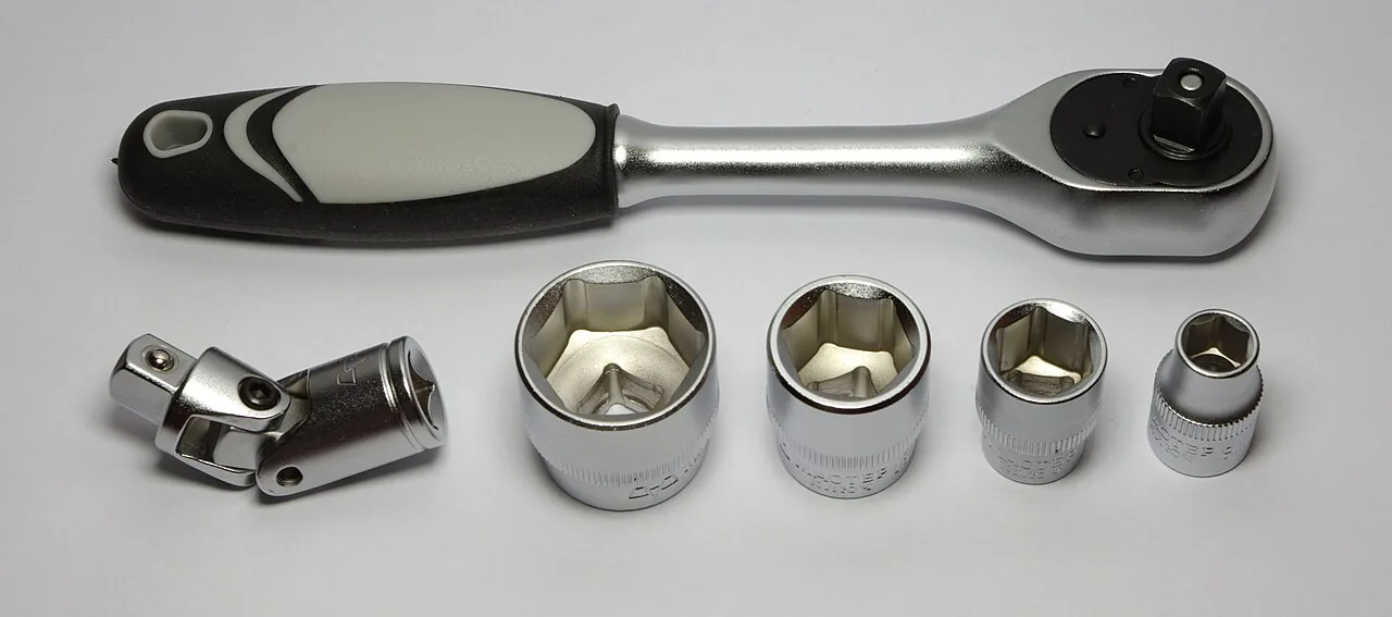 Socket wrench with a set of sockets laid out beside it