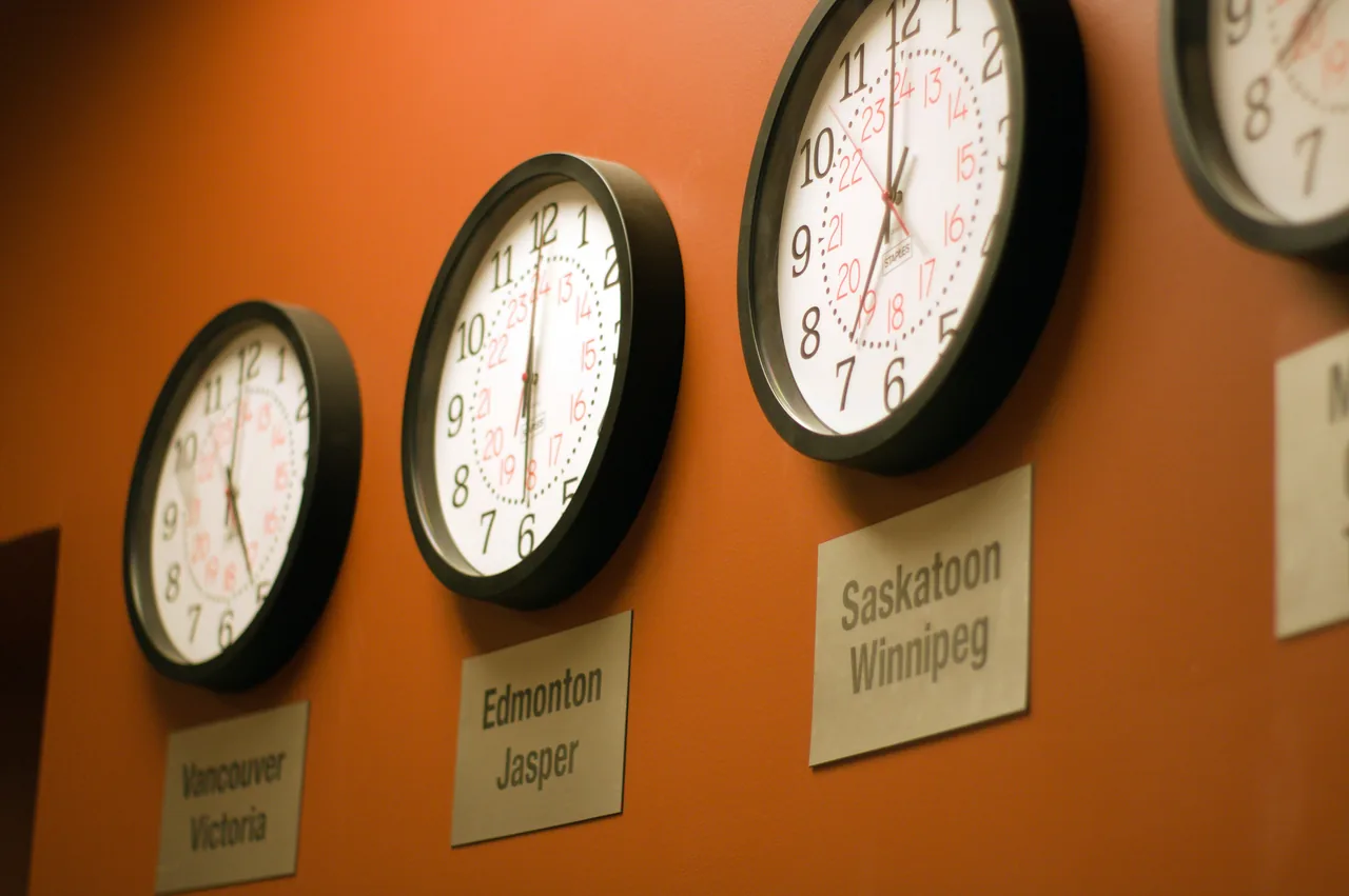 A row of wall clocks with city plates, one for each time zone