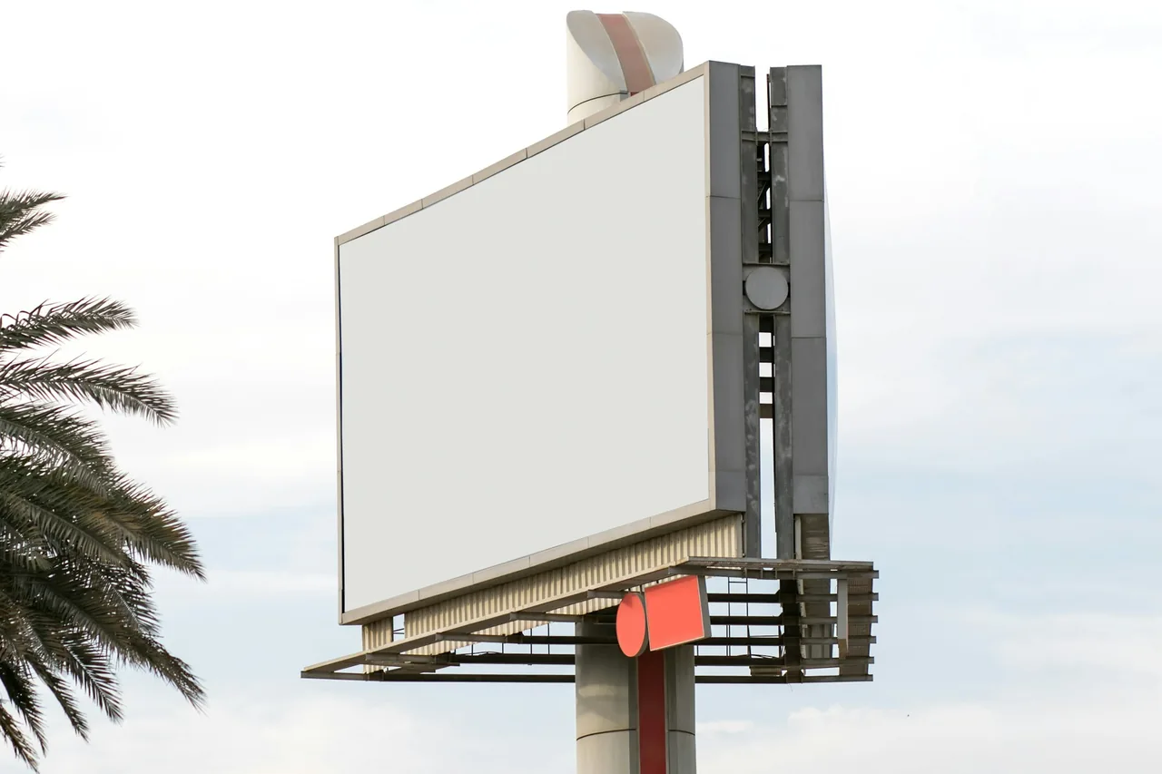 A blank billboard on a post against the sky