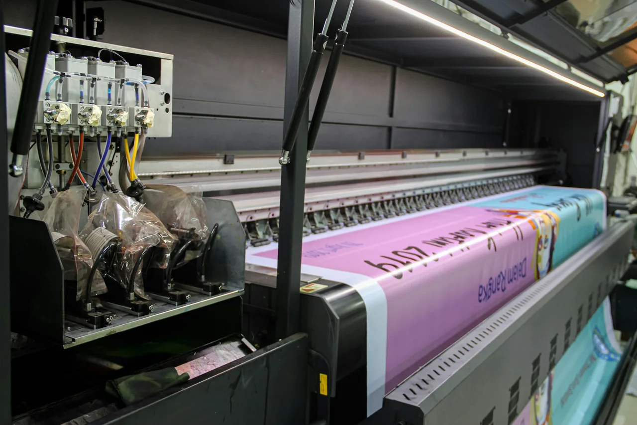 A wide-format printer running a banner off the roll