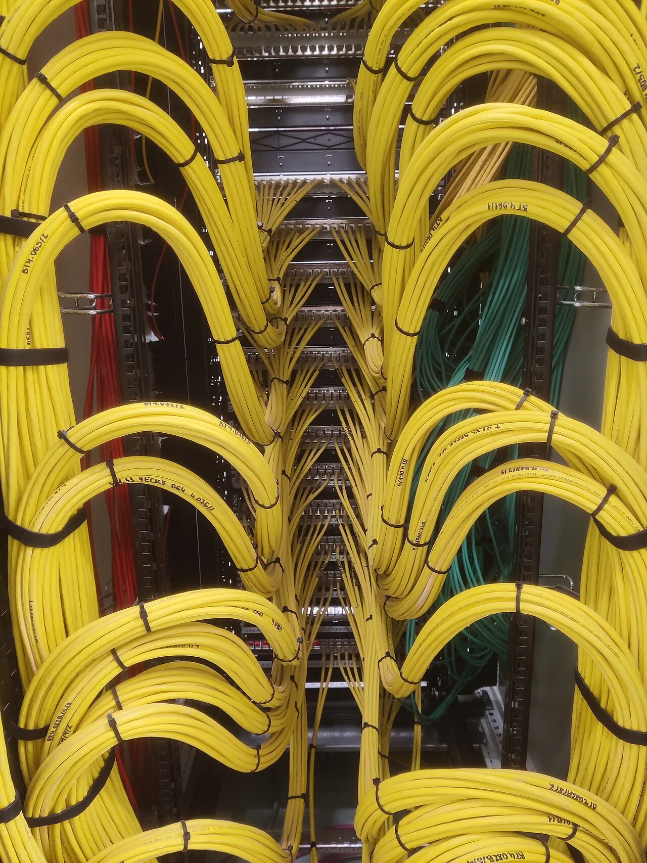 A patch panel with bundles of yellow network cables