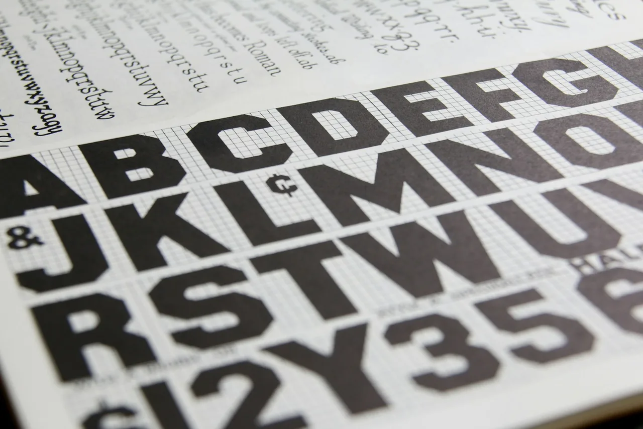 A specimen page with a large alphabet printed over a fine grid