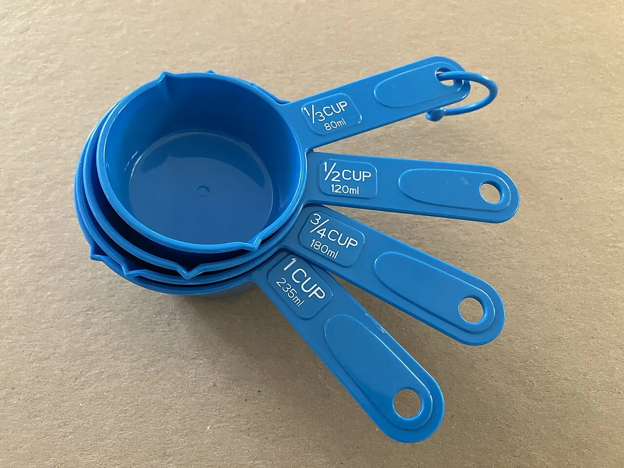 Four American measuring cups labelled in cups and millilitres
